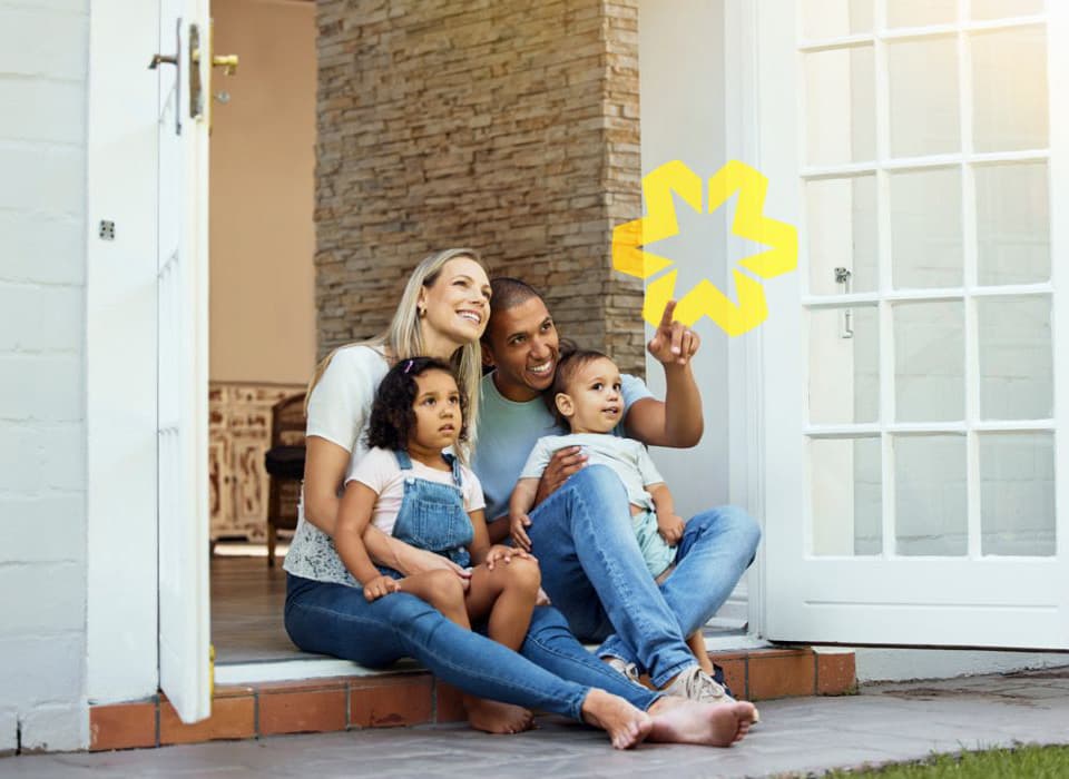 Happy family of four sitting on their front porch, enjoying a moment together outside their home.