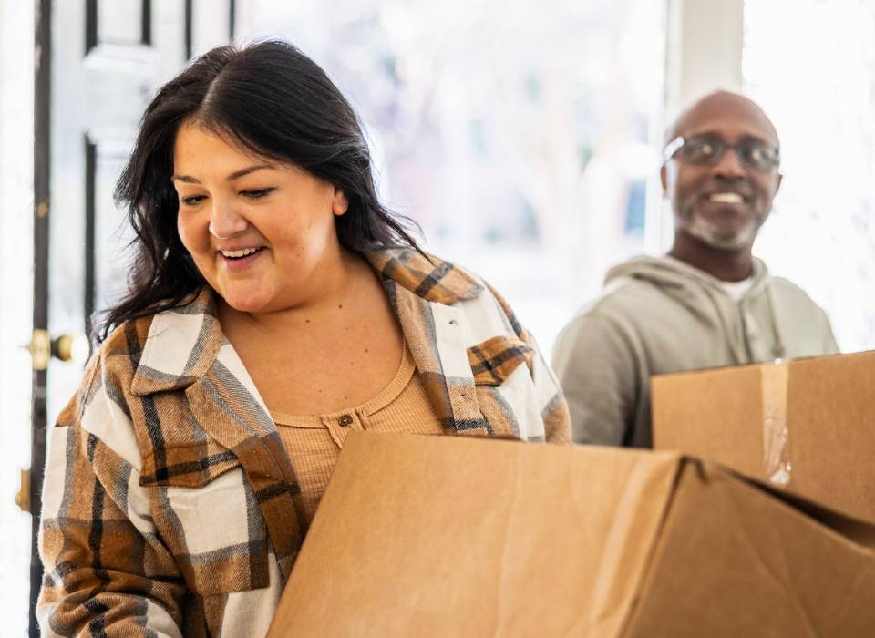 Woman and man holding moving boxes