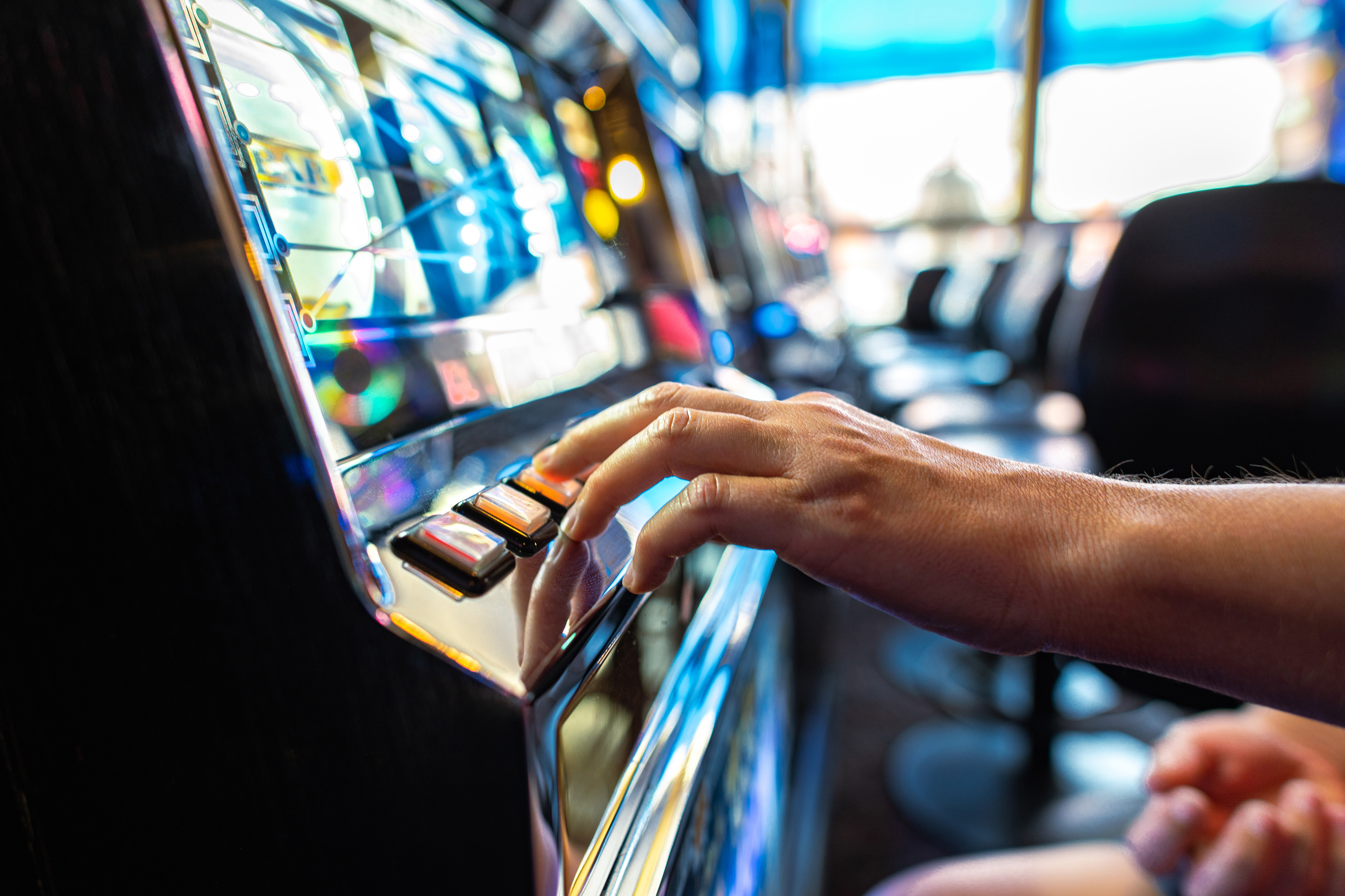 gambler pressing slot machine button